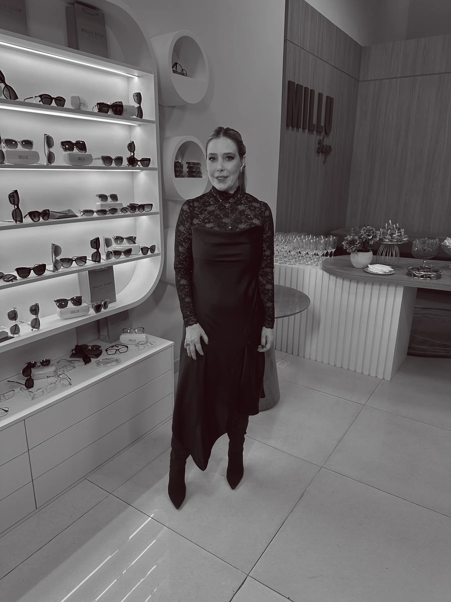 Andrea Simonetti em preto e branco, em loja de óculos